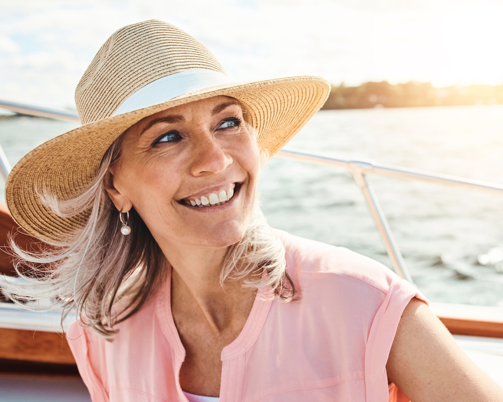 Smiling woman in a straw sun hat on a boat