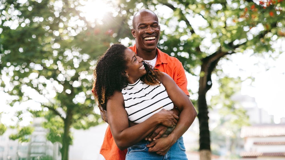 Laughing couple embracing in a park