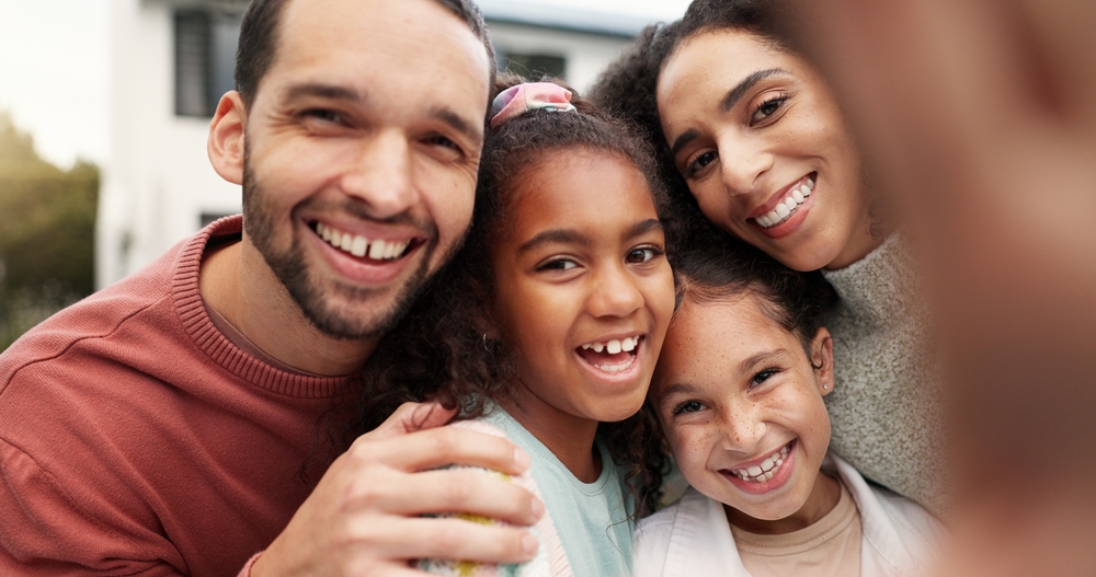 Smiling family of four taking a selfie together